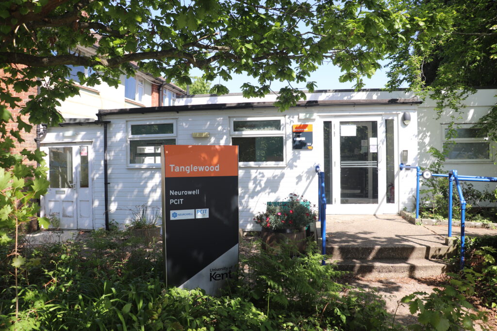 front of a white building with trees 